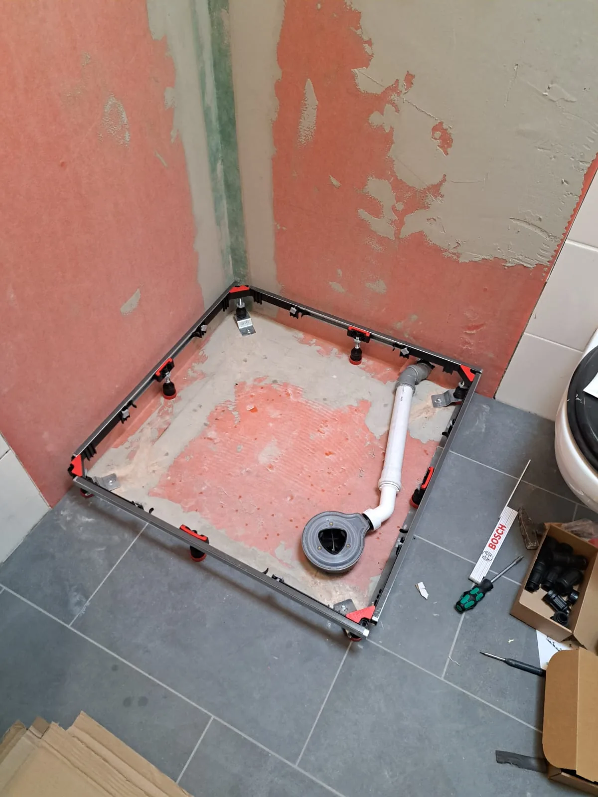 Vorher: Wannenträger und Bodenablauf im Rohbau, Wände noch abgeschlagen