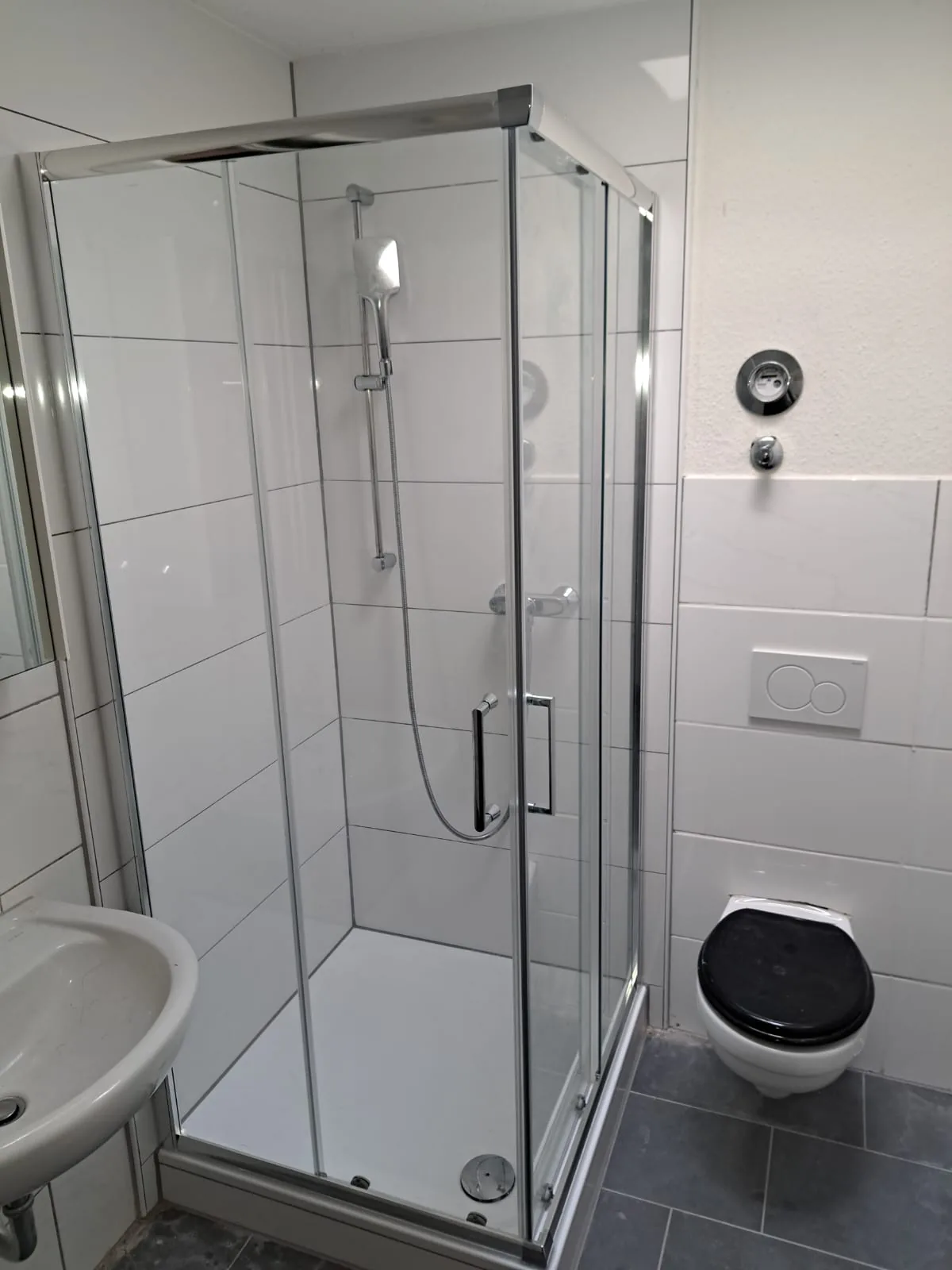 Nachher: fertige neue Dusche in Düren (Weierstraße) mit Eck-Glasabtrennung und weißen Fliesen