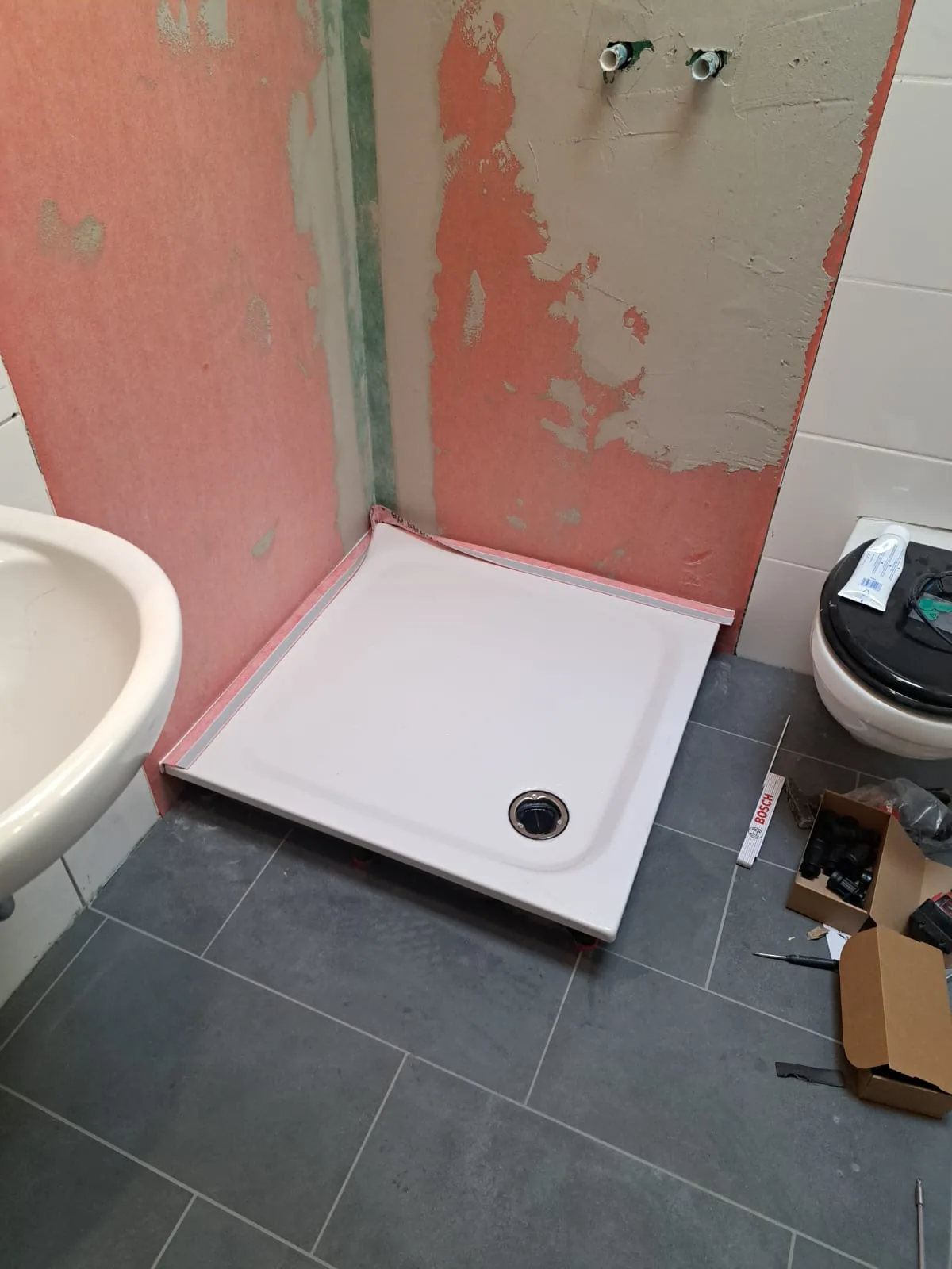 Vorher: Badezimmer in Düren im Rohbau, Wände abgeschlagen, neue Duschwanne wird gesetzt
