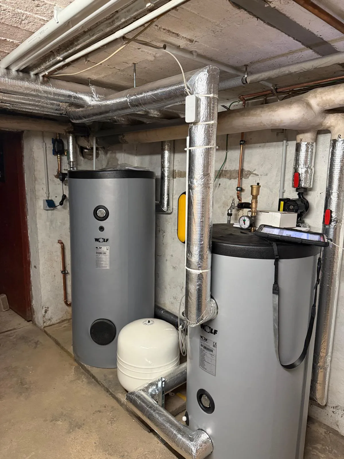 Nachher: moderne WOLF-Heizzentrale mit Puffer- und Warmwasserspeicher, sauber gedämmt im Keller
